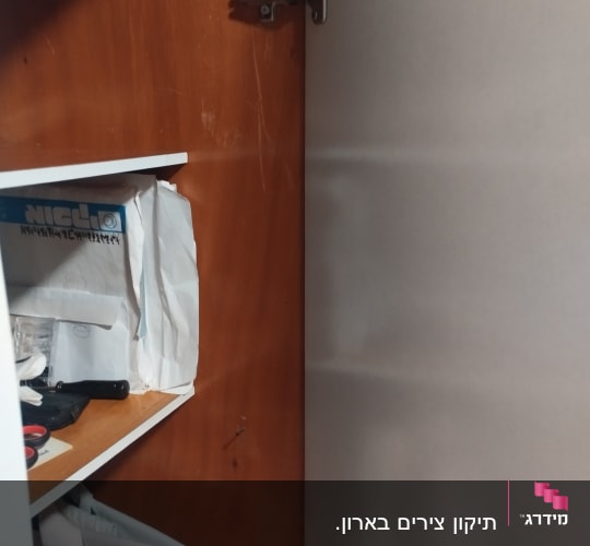 ארון פתוח עם צירים וכלי עבודה על מדף